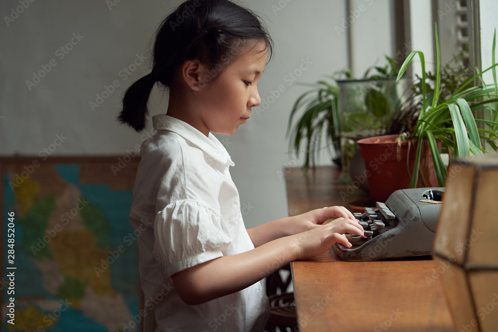 亚洲小女孩用老式打字机学习