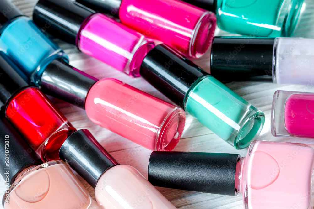 bottles of colored nail polish on wooden background