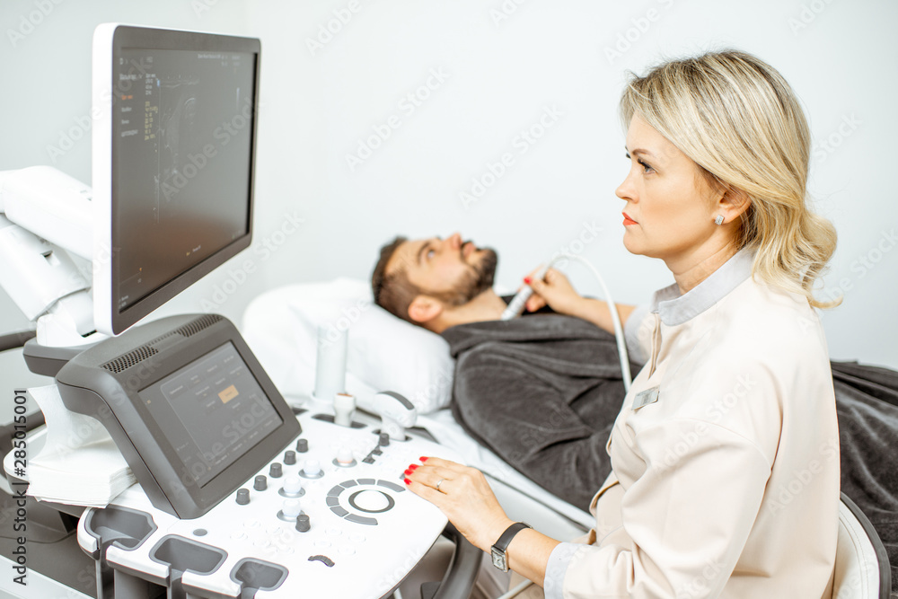 Doctor examining mens thyroid with ultrasound