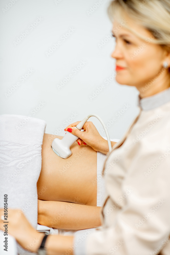 Doctor performs ultrasound examination of a woman