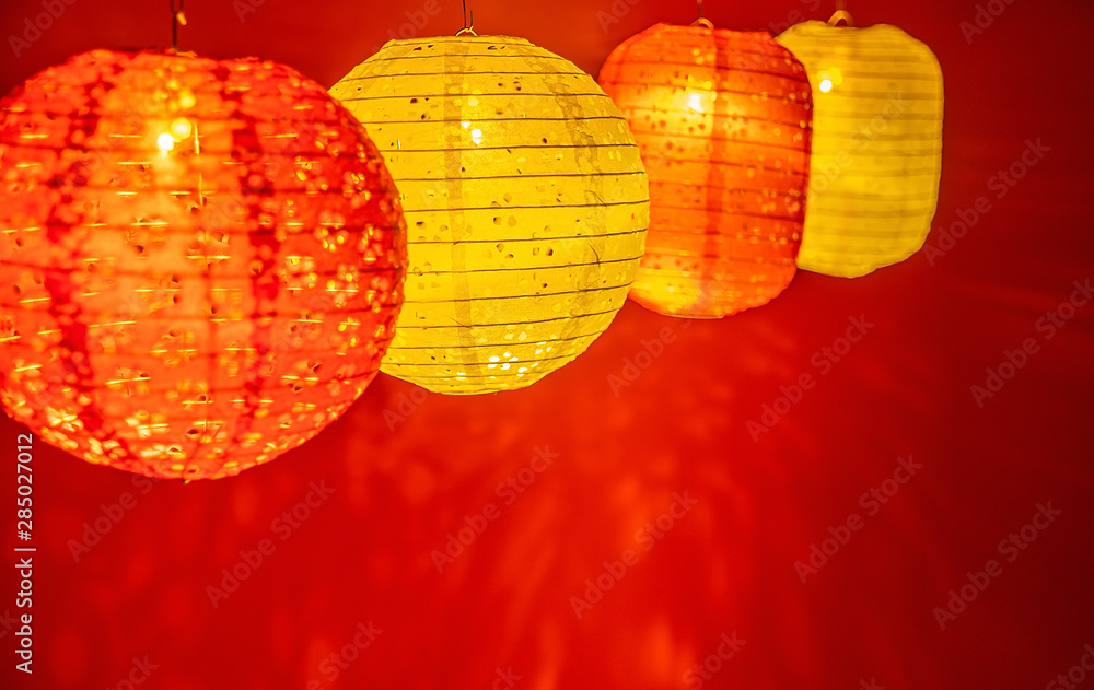 Beautiful retro colored paper lanterns hanging on a red background