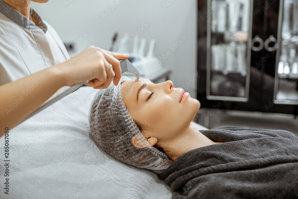 Woman during a vacuum hydro peeling at the luxury beauty salon, close-up view Concept of a professio