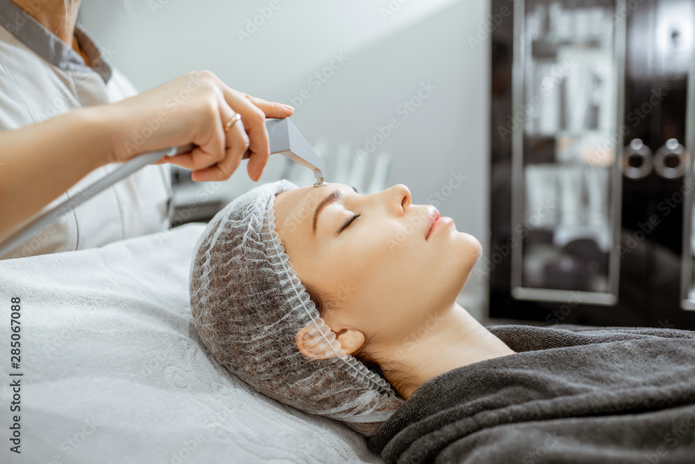 Woman during a vacuum hydro peeling at the luxury beauty salon, close-up view Concept of a professio