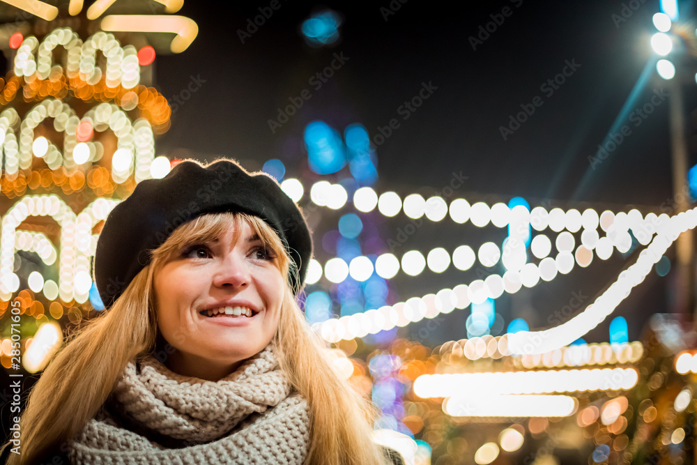 圣诞集市上快乐微笑的女孩，背景是明亮的bokeh