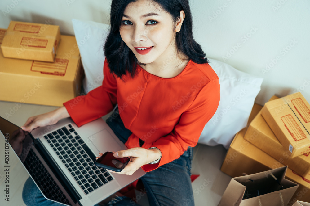 Young asian girl is freelancer with her private business at home office, working with laptop, coffee