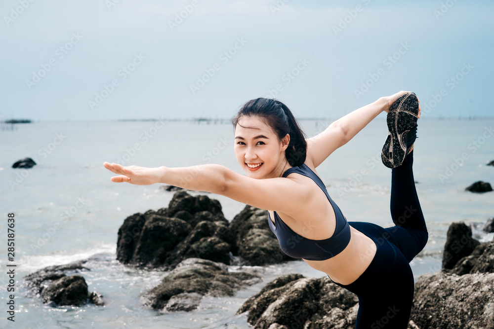 一个美丽的亚洲女人在早上跑步喝水。锻炼和户外运动