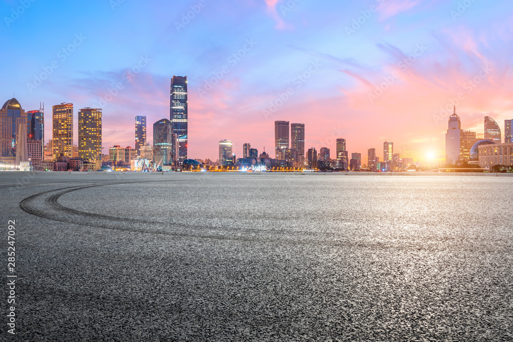 Shanghai skyline and modern buildings with empty race track at sunrise,China.