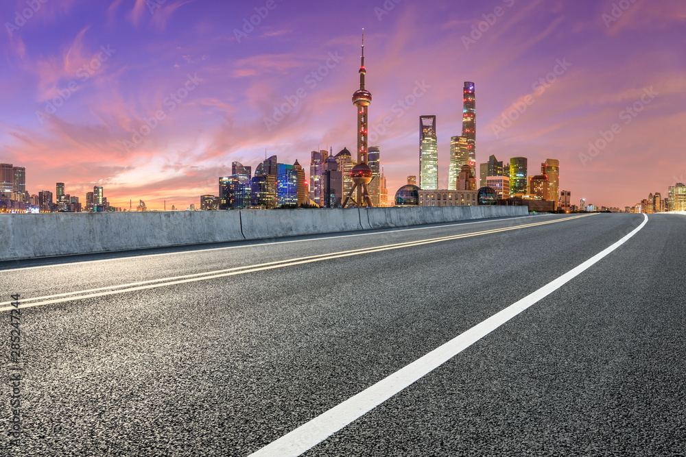 Shanghai skyline and modern buildings with empty asphalt highway at sunrise,China