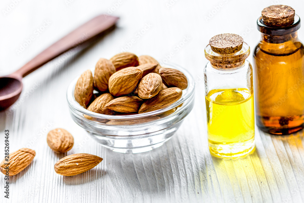 organic cosmetic with almond extract on table background