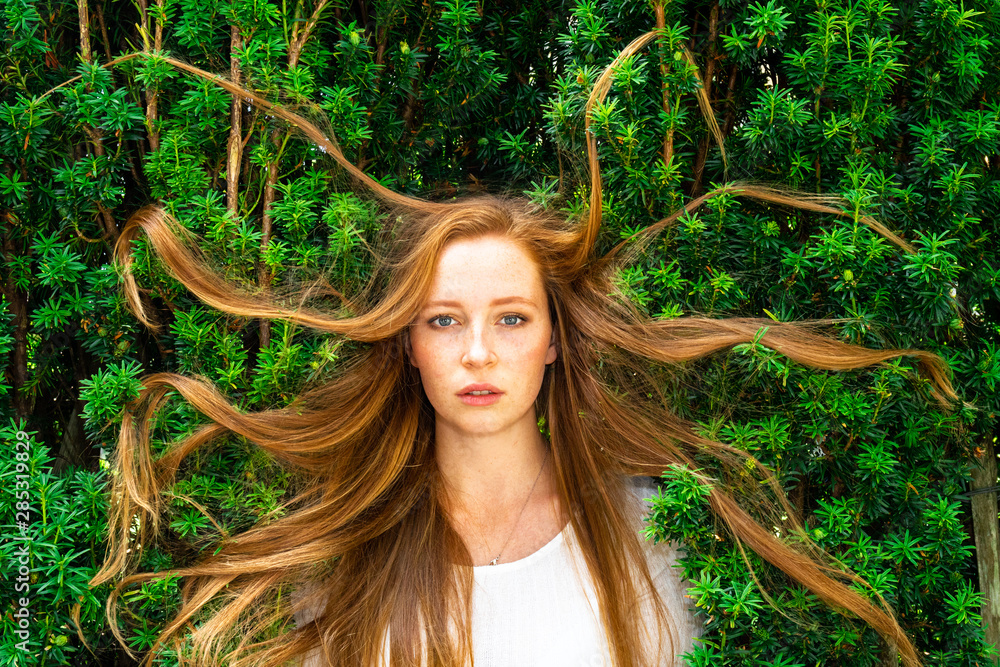 Beautiful redhead woman in hedge with tangled hair