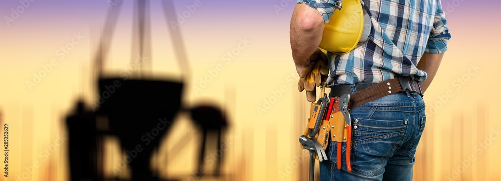 Male worker with tool belt on  background