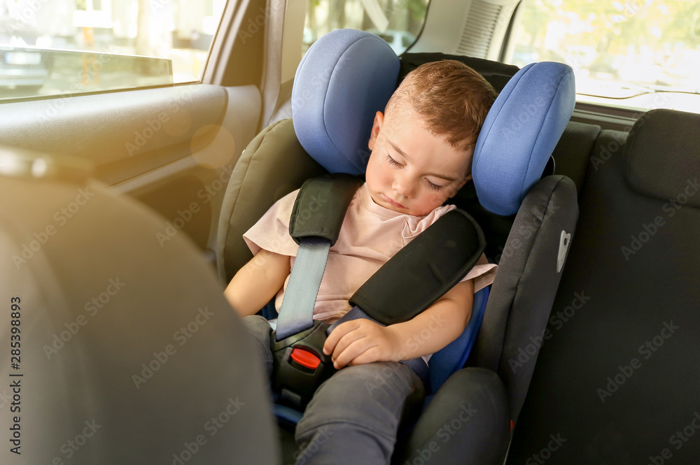 Sleeping baby boy buckled in car seat