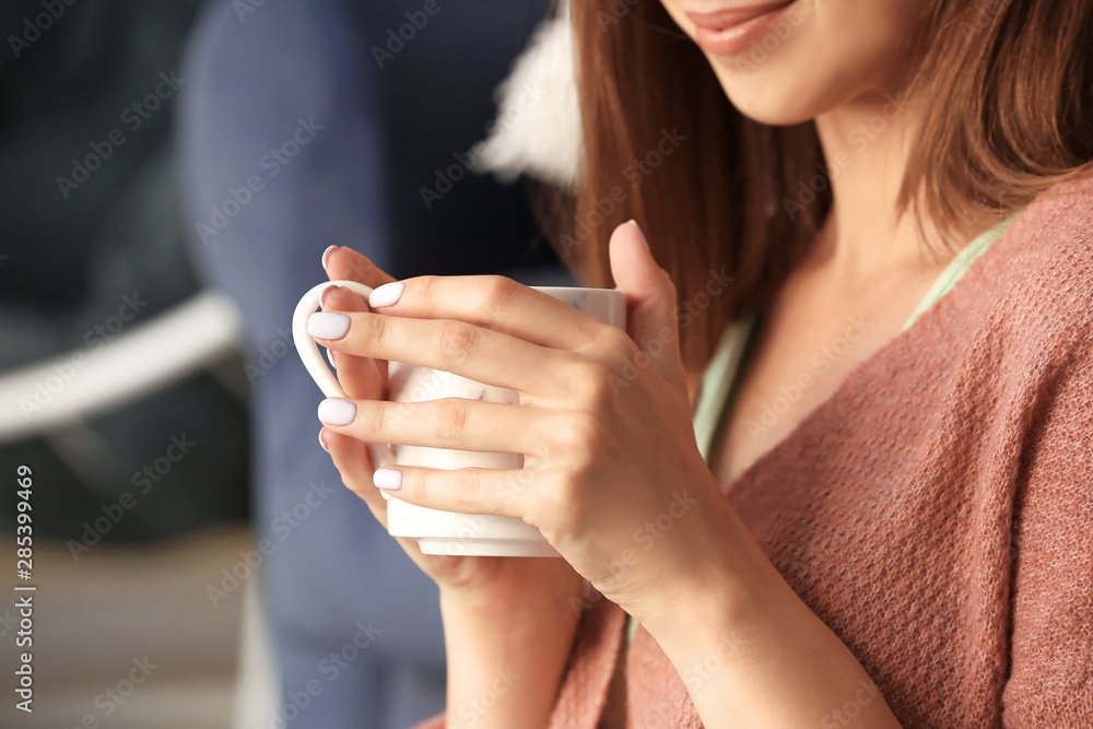 美丽的年轻女子在家喝茶，特写