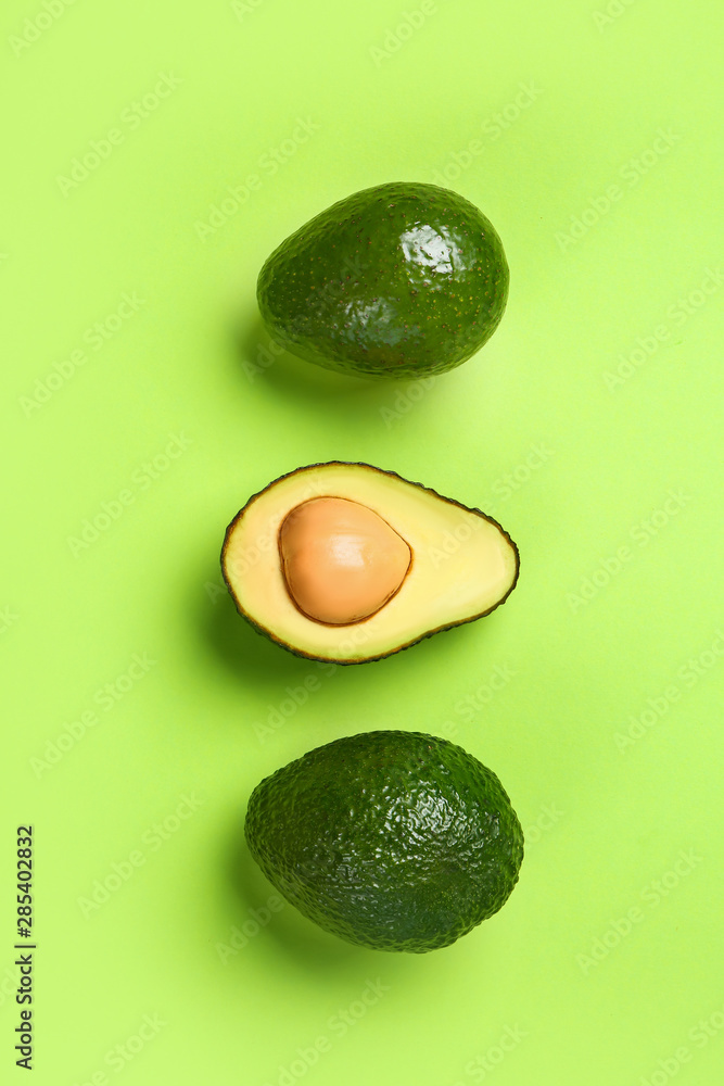 Ripe avocados on color background