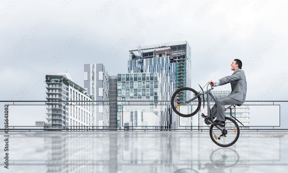 Man riding bicycle on penthouse balcony