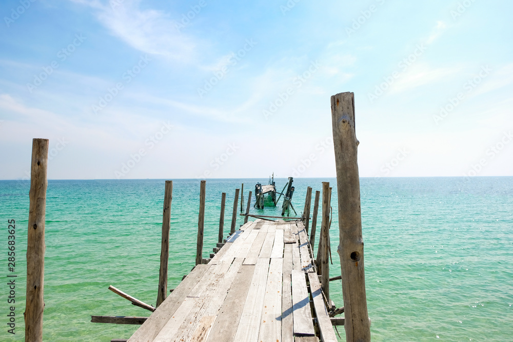 延伸到大海中的旧木桥透视图。度假和夏季场景。