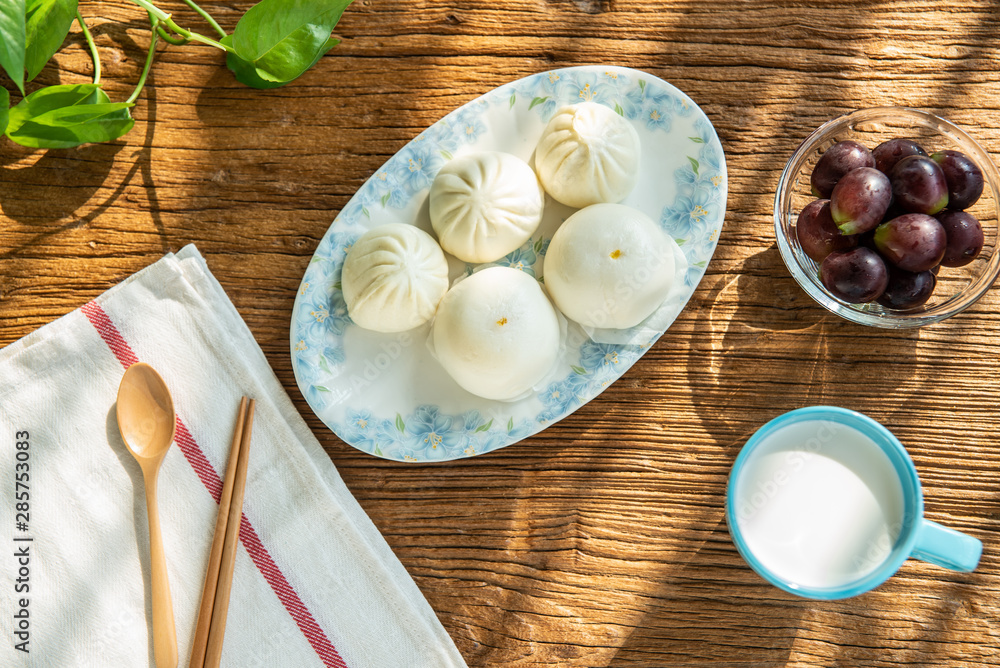 清晨的阳光照在木桌上营养丰富的早餐上。