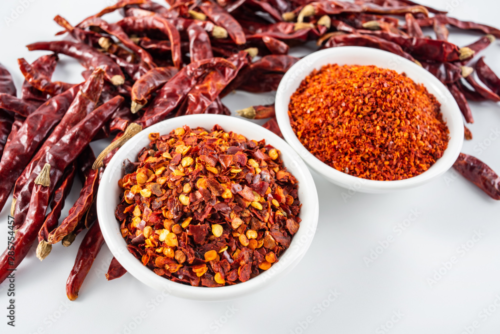 a plate of paprika and red dried chili on a white background