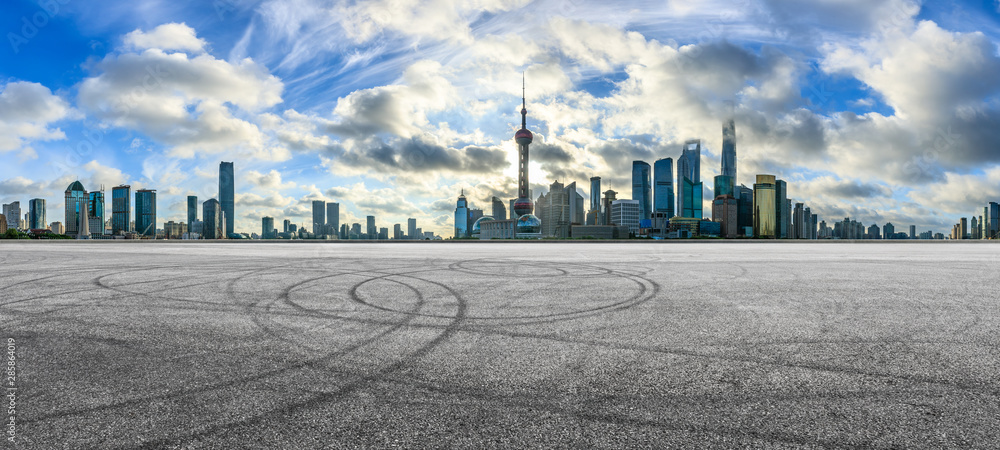 Empty race track and modern city scenery at sunrise in Shanghai,China.