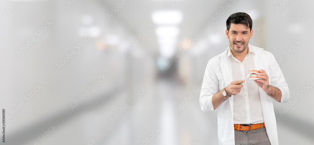 Young male dentist working in dental clinic. Dentistry care and medical service concept.