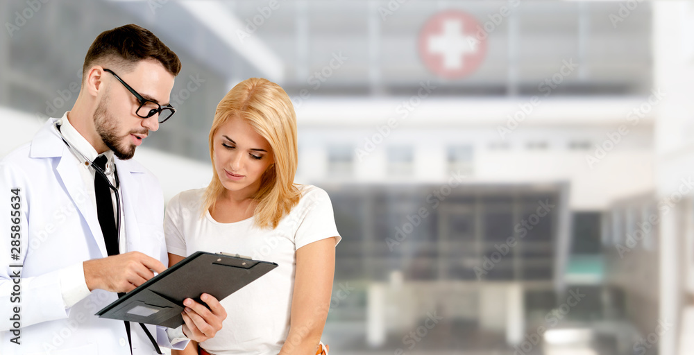 Doctor talking to patient in the hospital. The happy patient is listening to explanation from the do