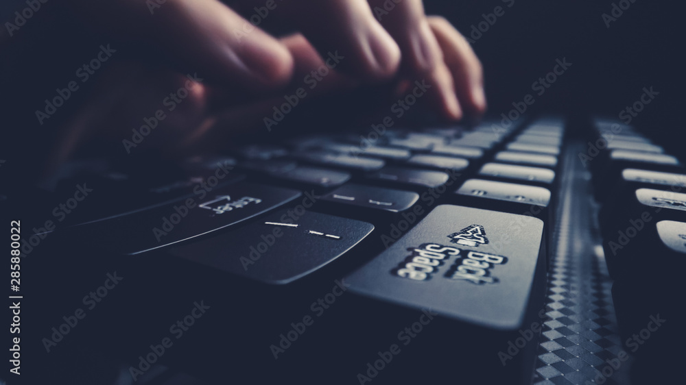 Close-up soft-focus finger typing on keyboard. Man hand using laptop computer in office. Programming