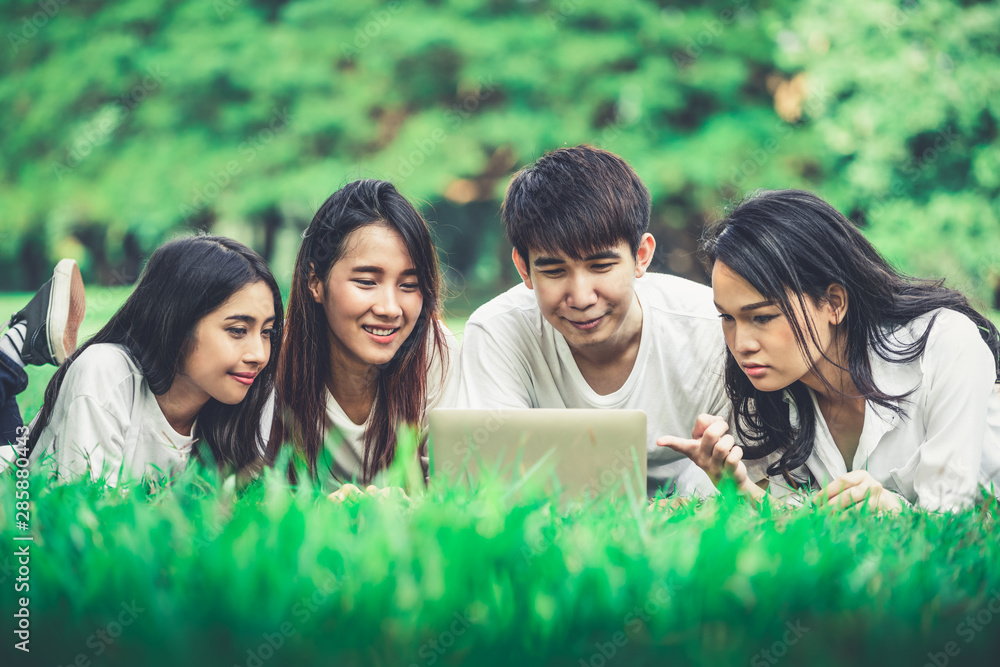 Team of young students studying in a group project in the park of university or school. Happy learni