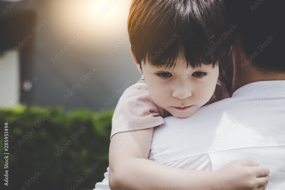 Handsome boy looks sad and little boy has to stay with dad because his dad and mother got separated 