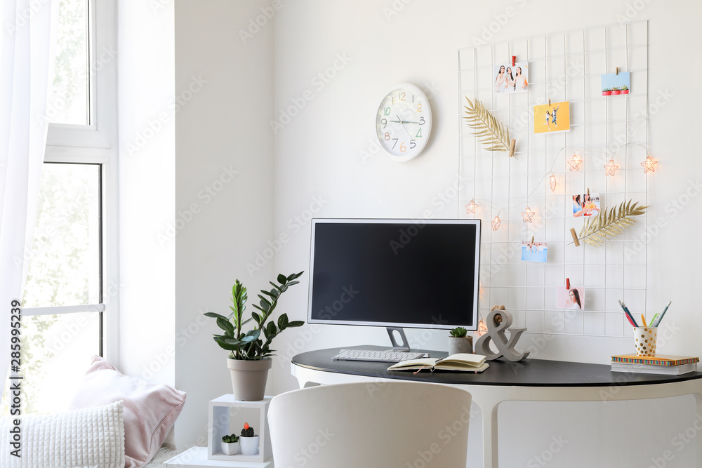 Workplace with mood board and computer in modern room