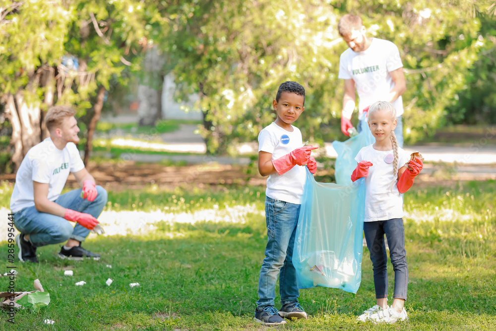 Little volunteers gathering garbage in park