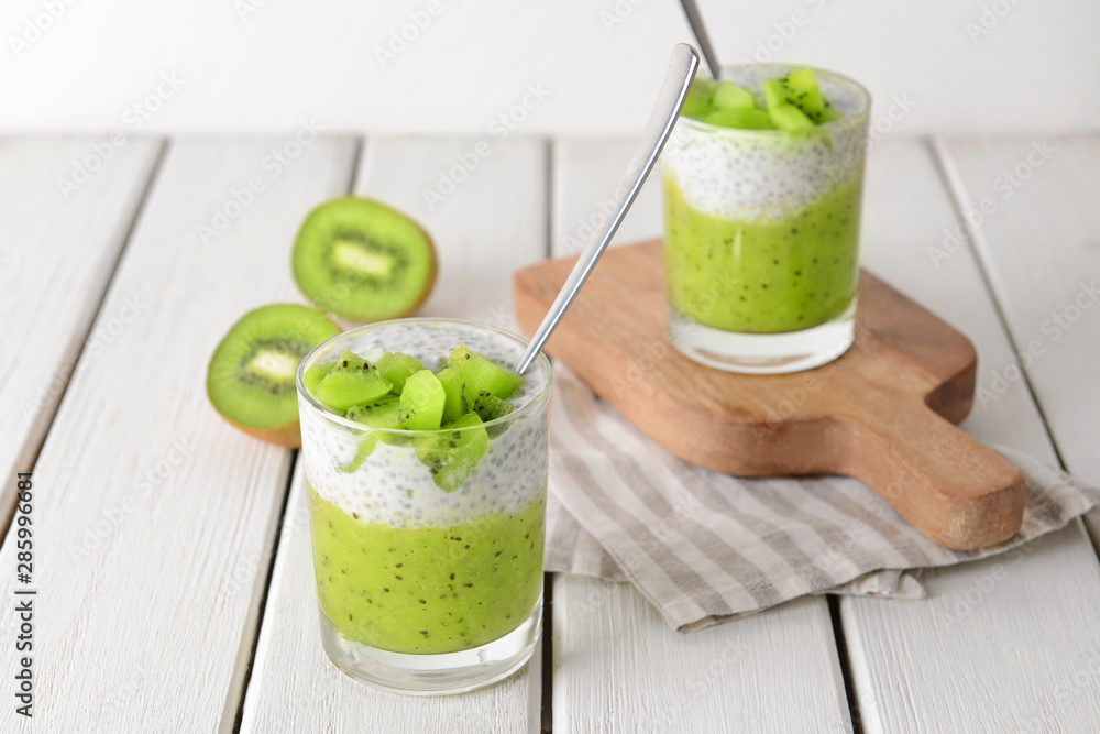 Glasses with tasty kiwi dessert on white table