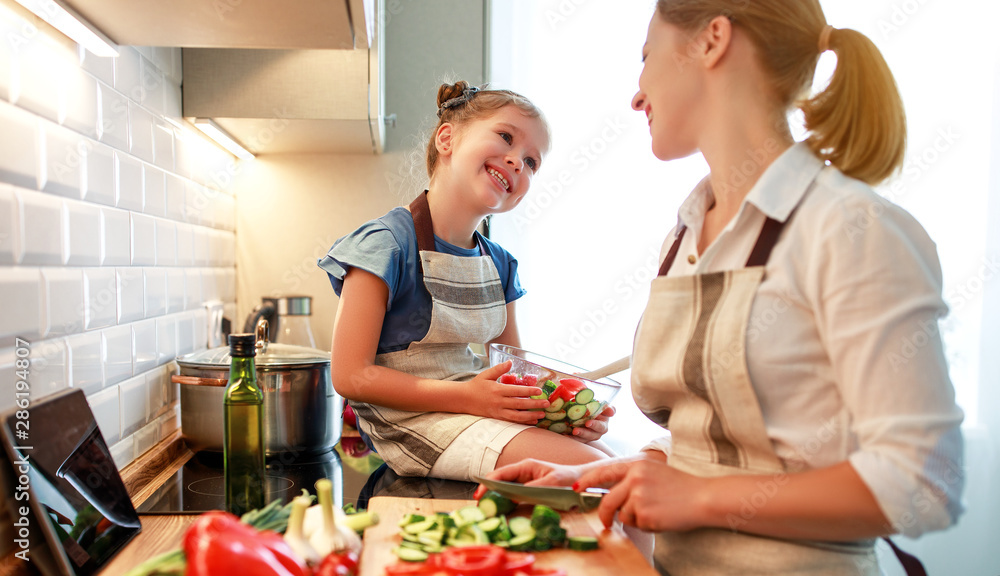 happy family mother with child girl preparing vegetable salad .