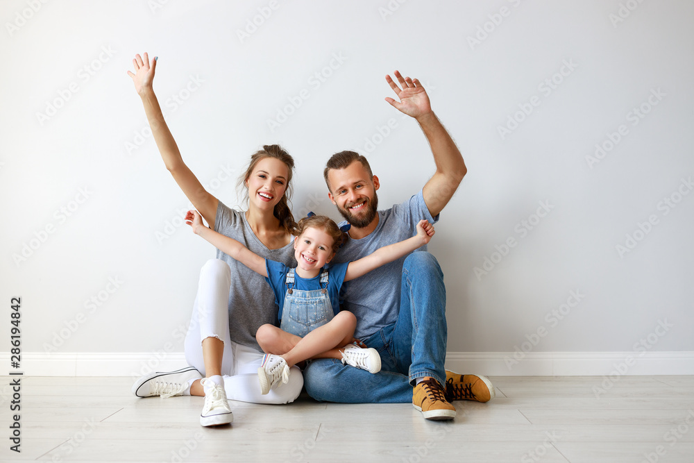 happy family mother father and child  near an empty wall.