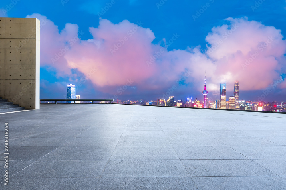 中国上海，空旷的广场层和城市天际线，夜晚有建筑。