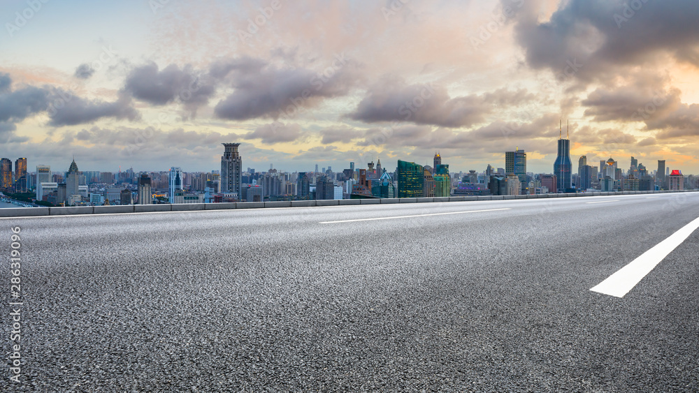 中国上海，日落时分，空旷的高速公路和城市天际线，建筑林立。