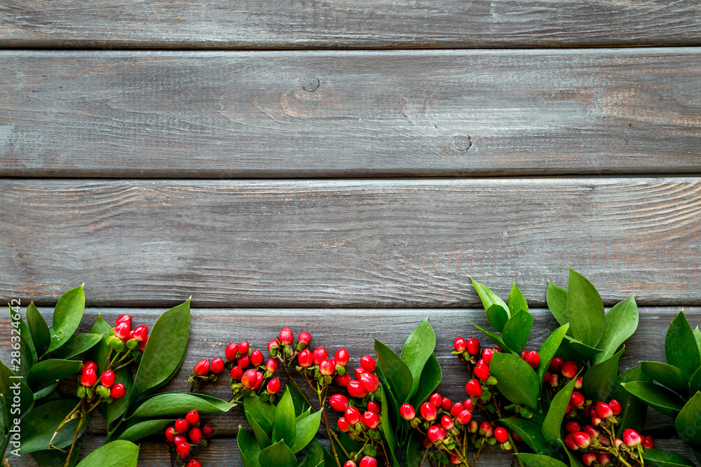 Summer pattern with green plants and red berries on wooden background top view mockup