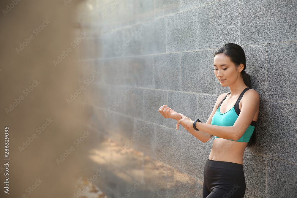 运动型亚洲女性在户外数脉搏