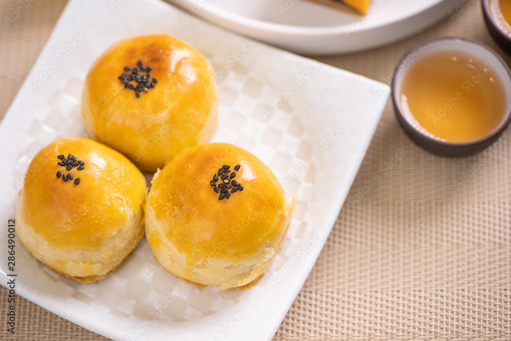 中秋节传统美食理念-惠特蓝纹板上的漂亮切月饼