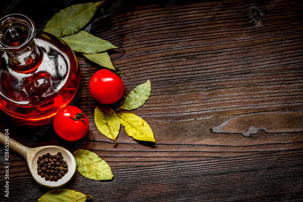 oil in glass bottle and chilli on dark wooden background