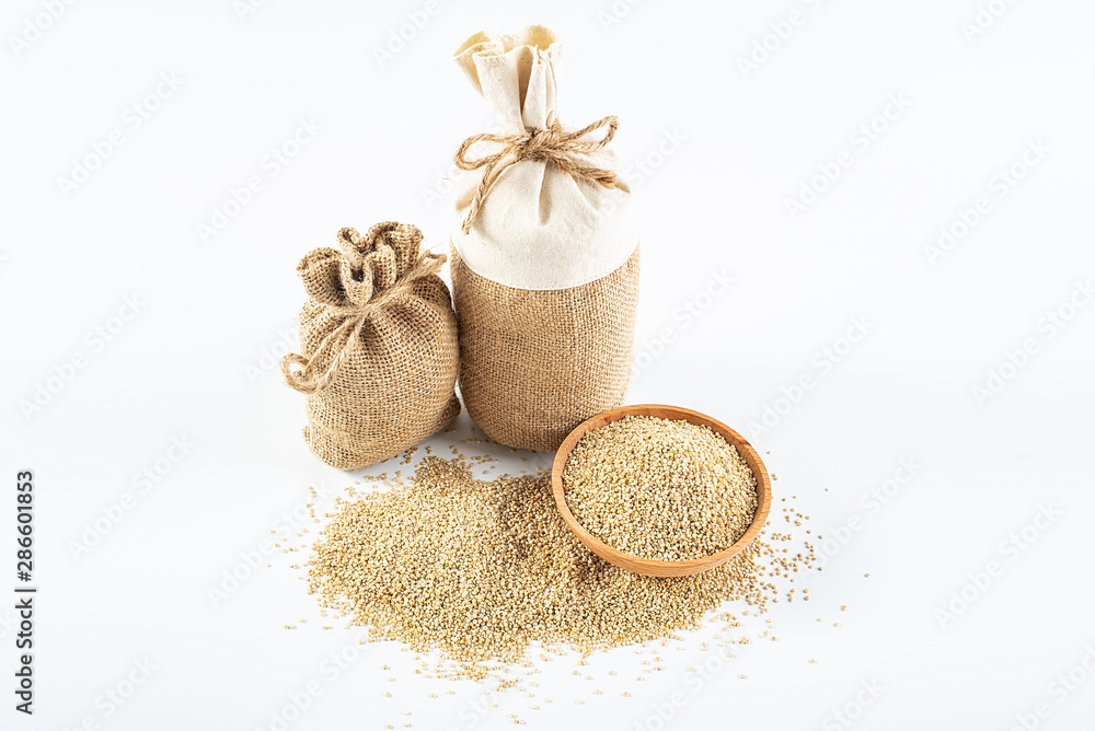 Sacks filled with grain and a bowl of buckwheat on a white background