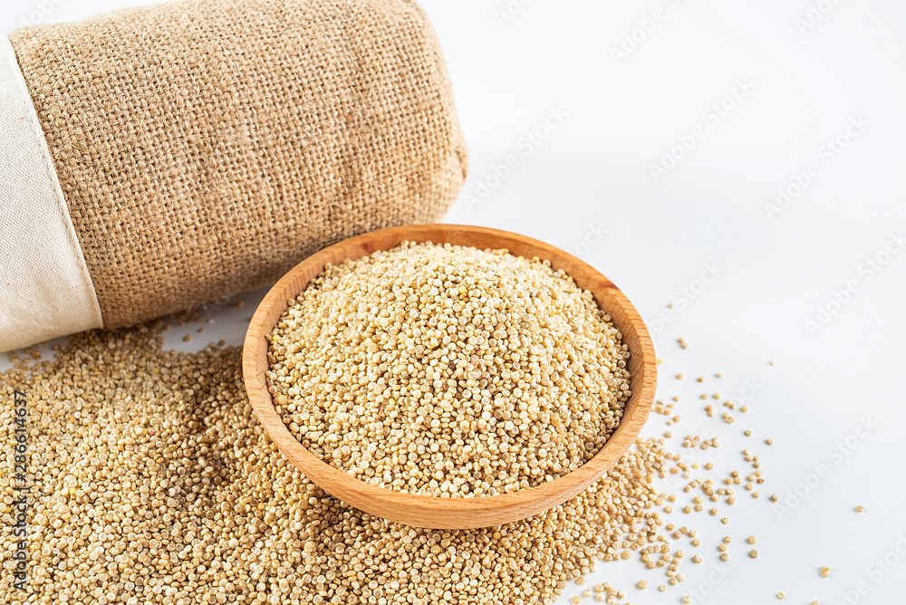 A wooden bowl of miscellaneous grains buckwheat on a white background