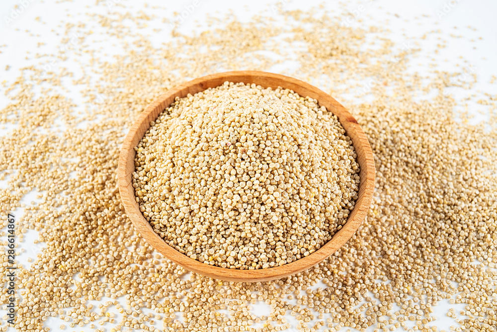 A wooden bowl of miscellaneous grains buckwheat on a white background