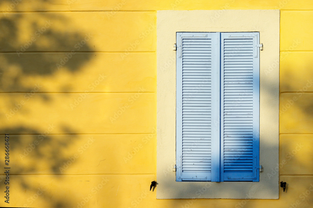  facade of mediterranean building with colorful shutter 