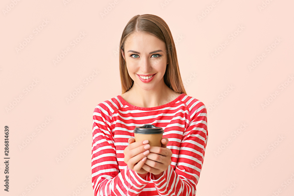 Beautiful young woman with cup of coffee on color background