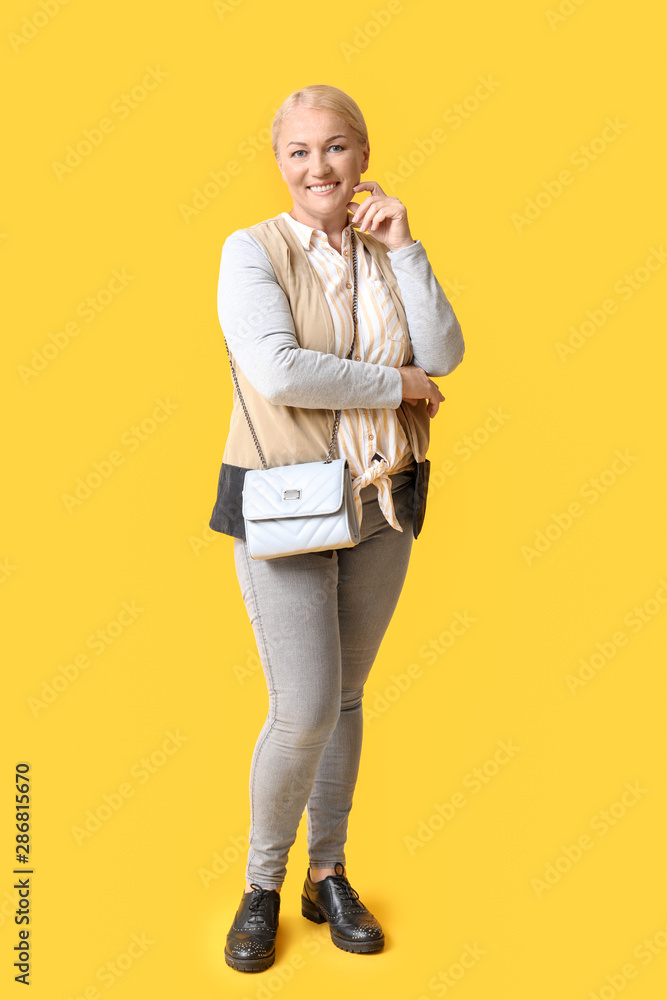 Stylish mature woman on color background