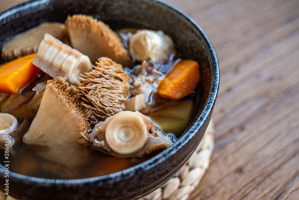 A bowl of Hericium erinaceus shark bone soup on a wooden table