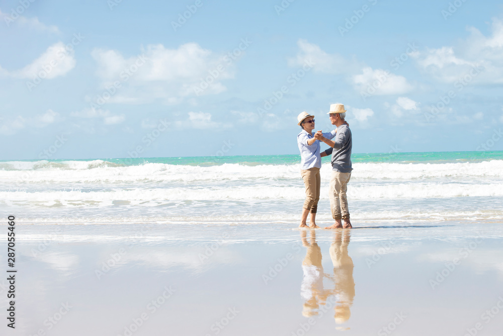 Happy asian senior couple  have fun and enjoy at the beach, senior man and woman dancing on the beac