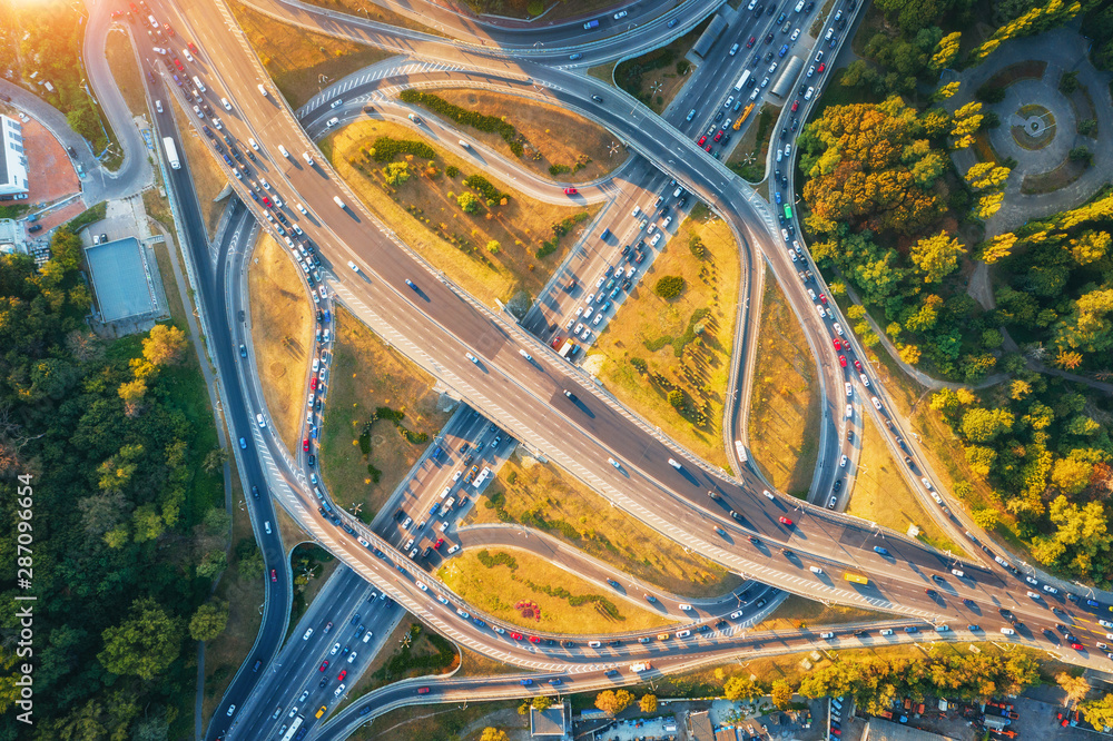 夏季日落时现代城市道路鸟瞰图。高速公路路口交通俯视图。兰