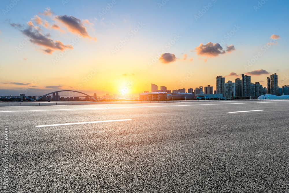 Asphalt road ground and city skyline at sunset in Shanghai,China.