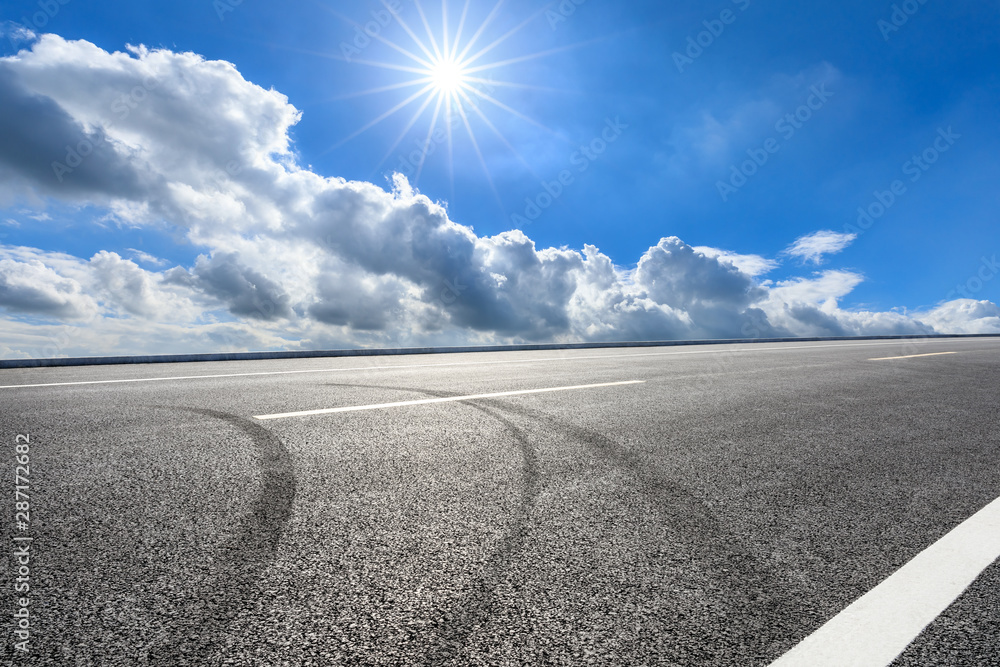 Asphalt highway road and blue sky with white clouds